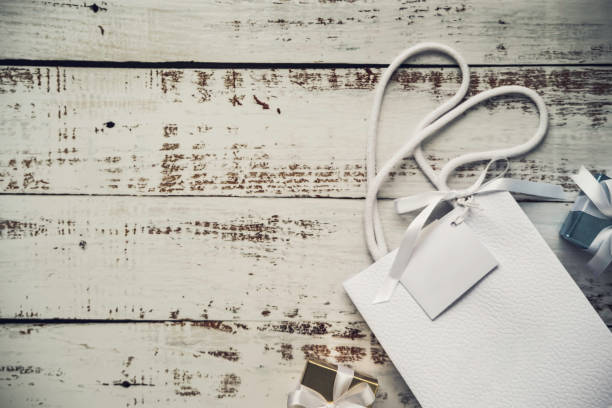 istock luxury white shopping bag leather pattern with empty space greeting card and gift box on the vintage old wooden table, top view 1284700024