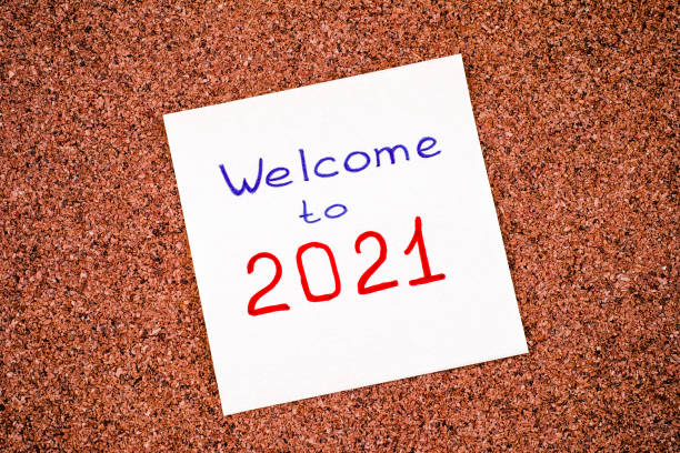 istock Note paper with phrase Welcome to 2021 on corkboard. 1284700810