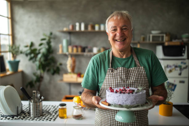 istock Senior man holding cake that he made in kitchen at home 1284701230