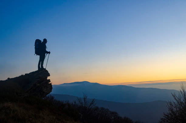 caminhante com mochila no topo da montanha aproveite o pôr do sol. símbolo da realização da vida. - sumbol - fotografias e filmes do acervo