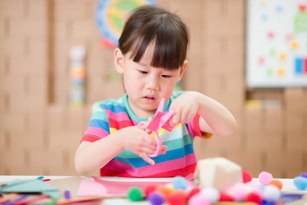 istock young girl using scissors cutting paper for making craft for home schooling 1284704980