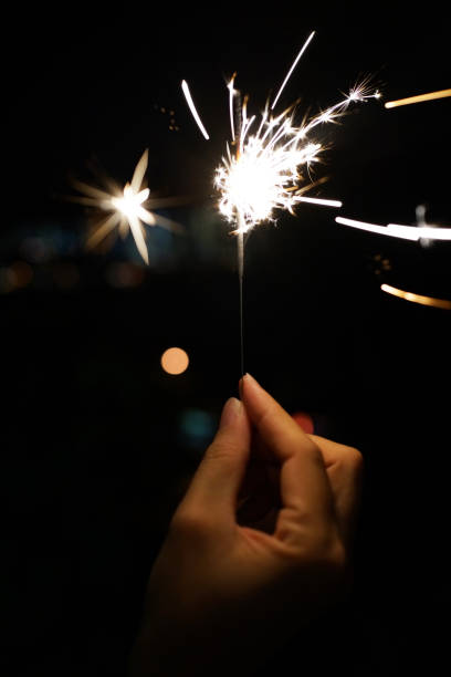 istock Cropped Hand Holding Sparkler At Night 1284705652