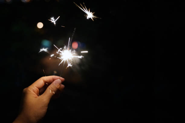 istock Cropped Hand Holding Sparkler At Night 1284705667