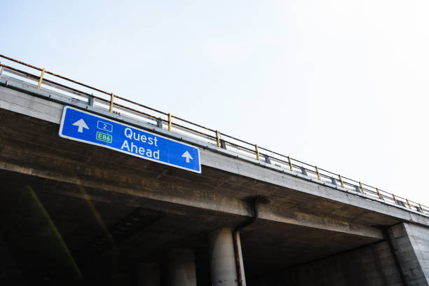 quest ahead blue road sign against clear sky - outdoor pursuit fotos imagens e fotografias de stock