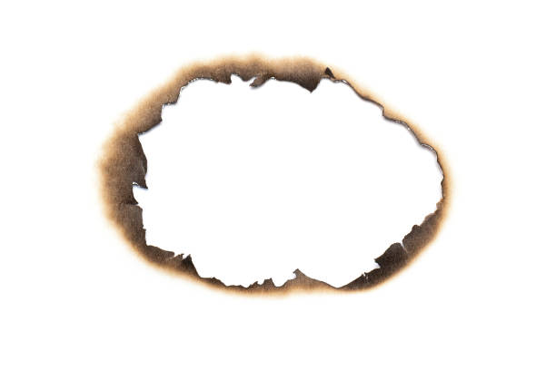 istock Fire burned hole white paper background texture isolated on white background. Paper burn mark stain 1284706692