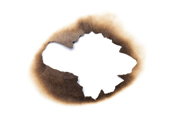 Fire burned hole white paper background texture isolated on white background. Paper burn mark stain Fire burned hole white paper background texture isolated on white background. Paper burn mark stain. at the edge of burnt frame grunge stock pictures, royalty-free photos & images