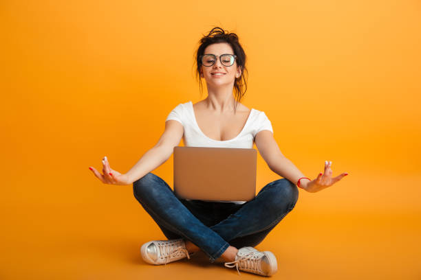 istock Concentrated young woman using laptop computer meditate. 1284709103