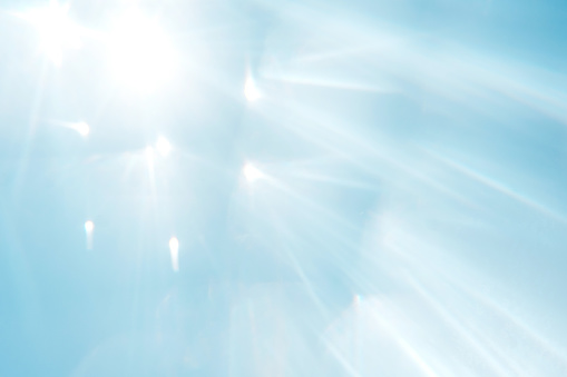 Blue blurred background with sun rays. Overlay, copy space. Clean sky and sun refraction.