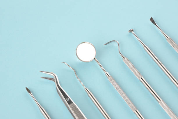 стоматологические инструменты на светло-голубом фоне - dental assistent стоковые фото и изображения