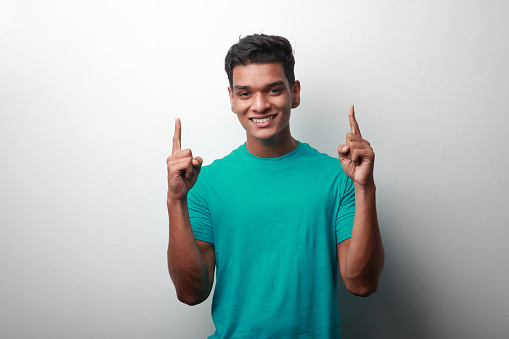Happy young man of Indian origin with a cheering gesture