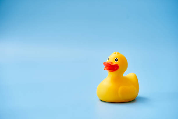istock Isolated yellow rubber duck with a copy space on a blue background 1284718855