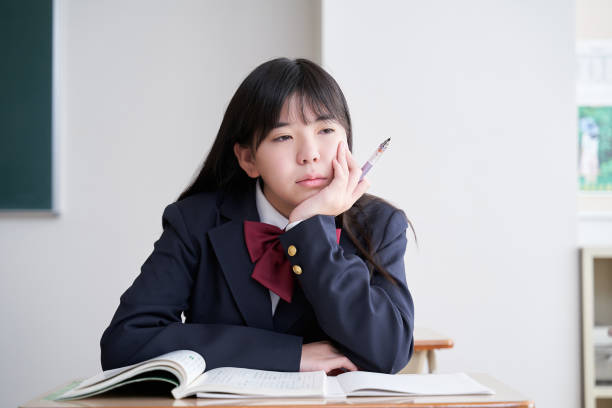 日本の中学生の女の子が教室でモチベーションを失う - learning boredom studying child ストックフォトと画像