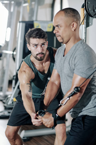 istock Fitness trainer controlling exercising man 1284720348