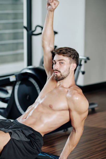 istock Fit man sitting on bench in gym 1284720409