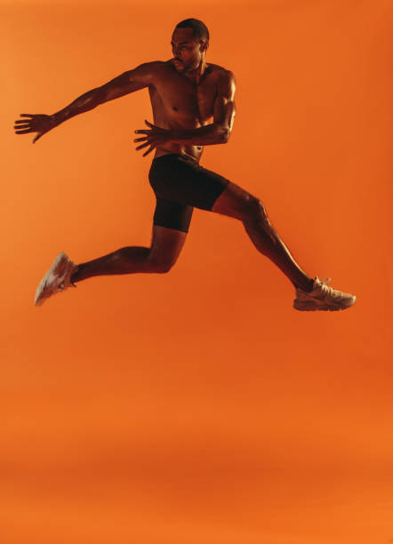 istock Fit man working out on orange background 1284720487