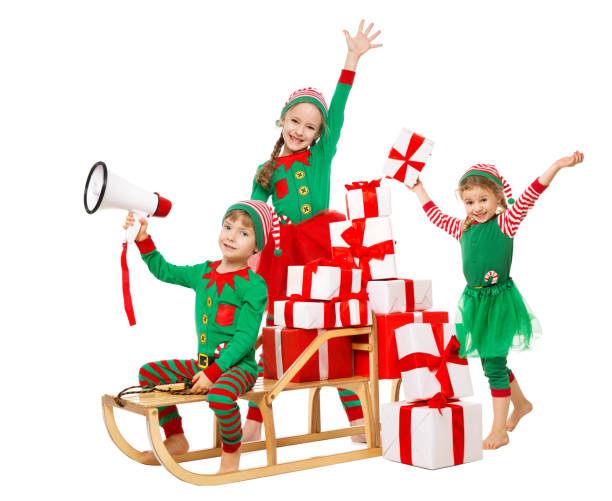 funny christmas kids with megaphone preparing new year gifts. santa claus helpers, cute little elves on sleigh packing christmas present boxes in stack - marketing megaphone child using voice imagens e fotografias de stock