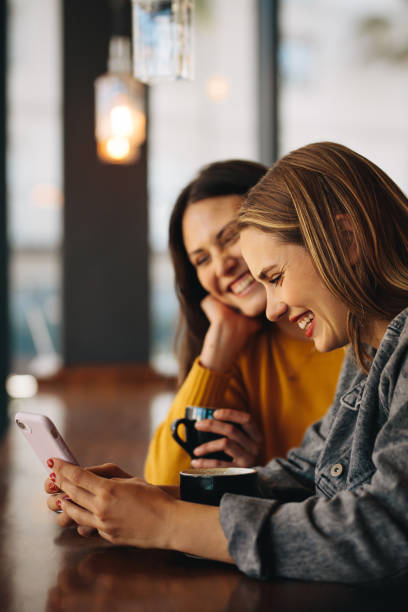 istock Women sitting at cafe and using phone 1284720813
