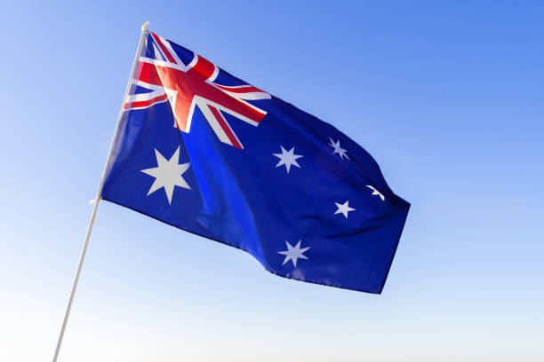 istock Flag of Australia waving against blue sky 1284721850