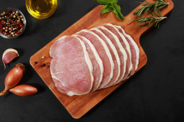 Sliced Ham Sliced Ham or Pork on chopping board preparing to cook uncooked bacon stock pictures, royalty-free photos & images