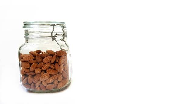 istock Almonds are packed in glass bottles on a white background. 1284725652