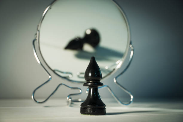 A chess piece is reflected in the mirror. Things and people are not what they seem. Reassessment of their abilities. Psychology, motivation. Power of thought. Never give up, always go for your goal.