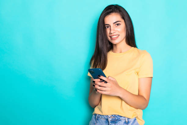 istock Young woman use phone isolated on turquoise background 1284733361