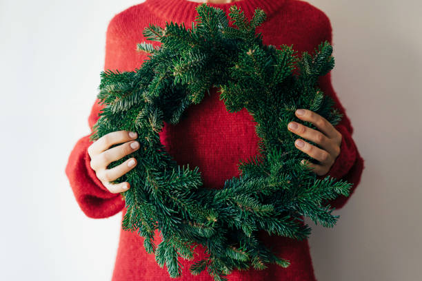 istock woman holding christmas wreath 1284734263