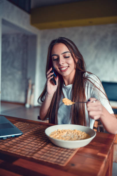 istock Female Eating Cereal And Talking On The Phone 1284737812