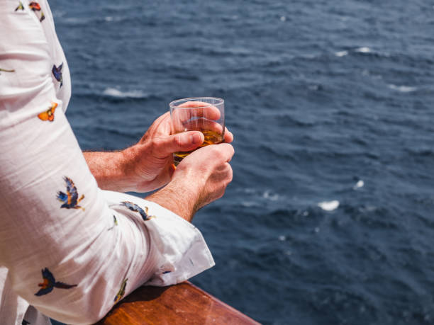 istock Fashionable man holding a beautiful glass on the open deck 1284737981