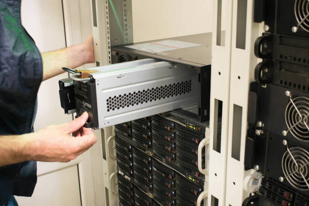 Changing the power module in the server room close-up. Working with equipment in the datacenter rack. Replacing the battery in an uninterruptible power supply. Changing the power module in the server room close-up. Working with equipment in the datacenter rack.Replacing the battery in an uninterruptible power supply. power supply stock pictures, royalty-free photos & images