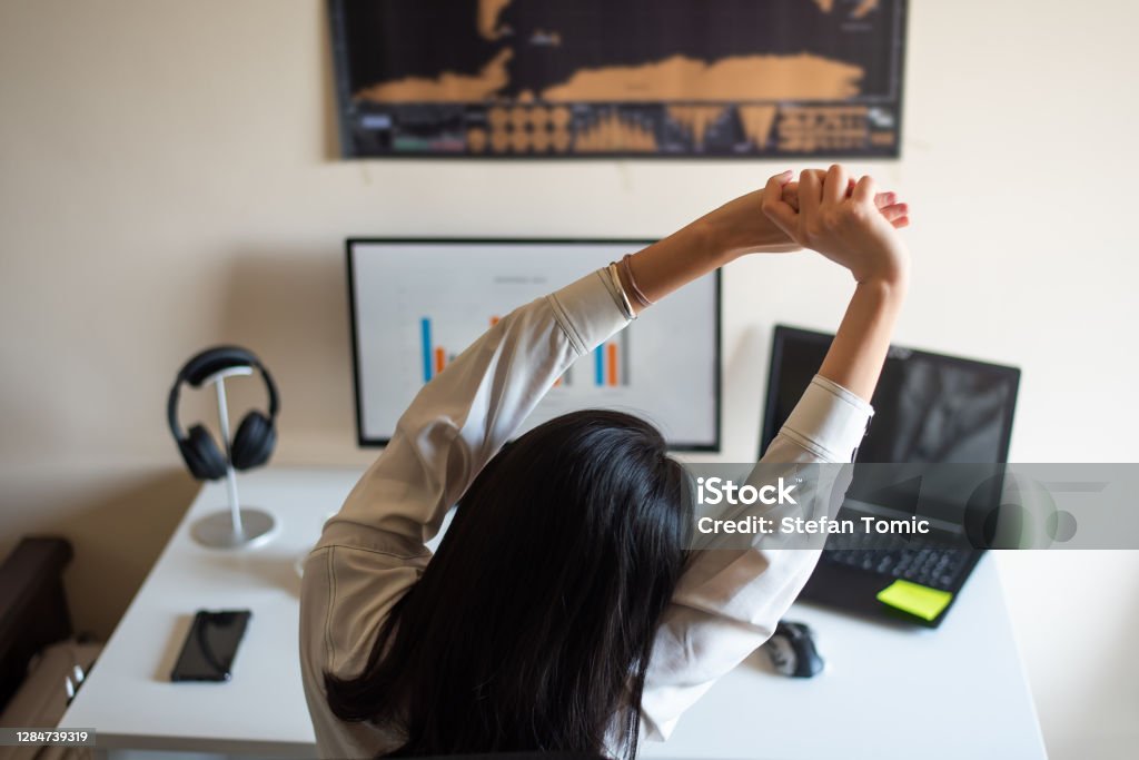 Femme s’étirant tout en travaillant d’un bureau à la maison - Photo de Ergonomie libre de droits