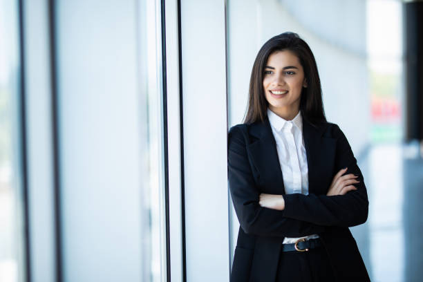 istock Young businesswoman standing with arms folded at office 1284740033