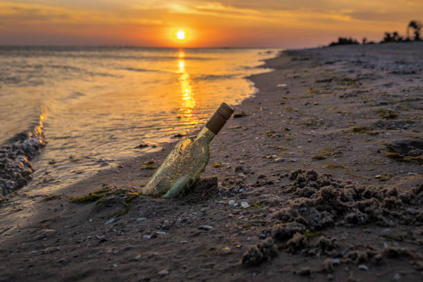 бутылка с сообщением застрял в песке - stranded message in a bottle island document стоковые фото и изображения
