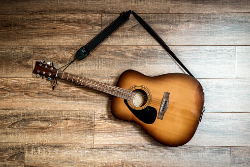 professional acoustic guitar hanging on the wooden wall