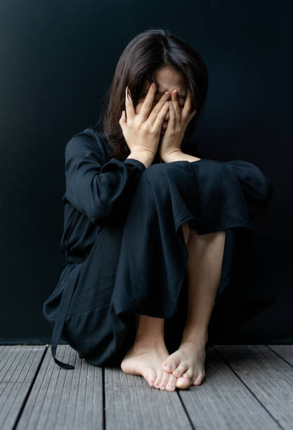 istock Depressed woman sitting on floor 1284743850