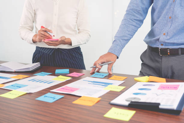 istock Creative group of business people brainstorming use sticky notes picking to share idea on table decision Choosing Concept for developing plan in business conference room 1284744549