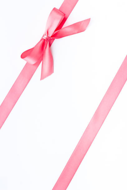 istock Pink ribbon with bow isolated on white. Top view, copy space 1284745464