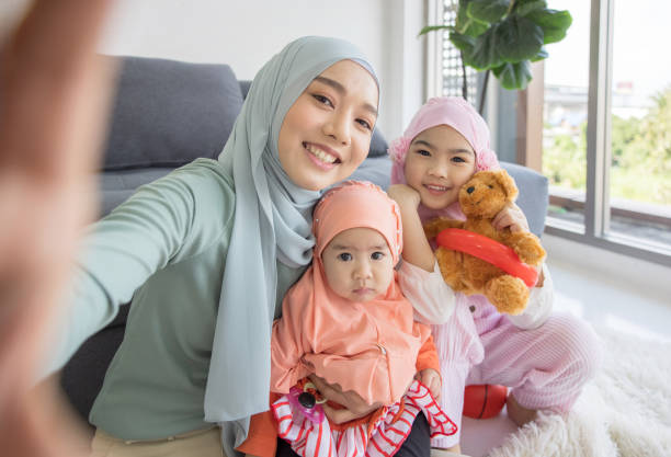мусульманская мать будущего материнства в хиджабе и принимая автопортрет в гостиной - human pregnancy baby shower image color image стоковые фото и изображения