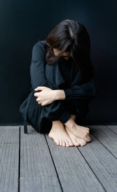 istock Depressed woman sitting on floor 1284745672