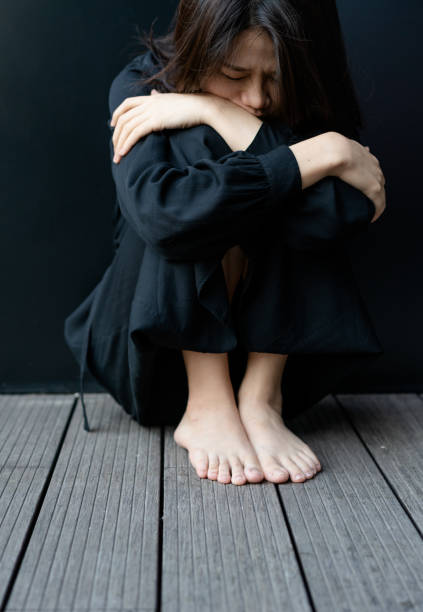 istock Depressed woman sitting on floor 1284745831