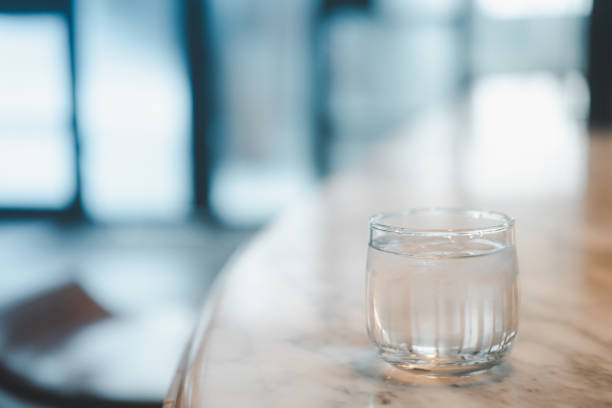istock Clean water in small glass on table. Healthy concept 1284746150