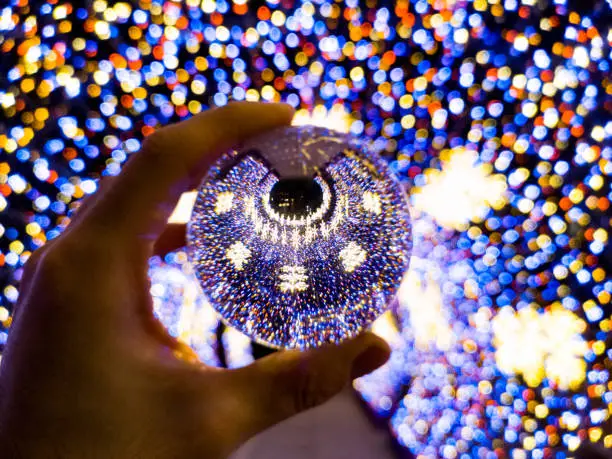 Round colorful christmas tunnel made of christmas lights reflected in crystal glassy lensball