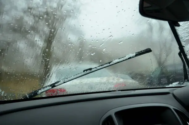 looking through windscreen  with raindrops and car in front