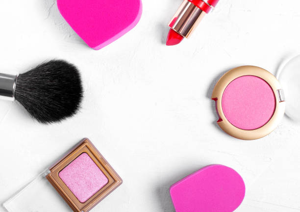 istock Make up brush, heart shaped sponge, red lipstick, pink eyeshadows and blusher on white 1284746225