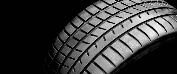 istock New wheel tire close-up on black 1284747204