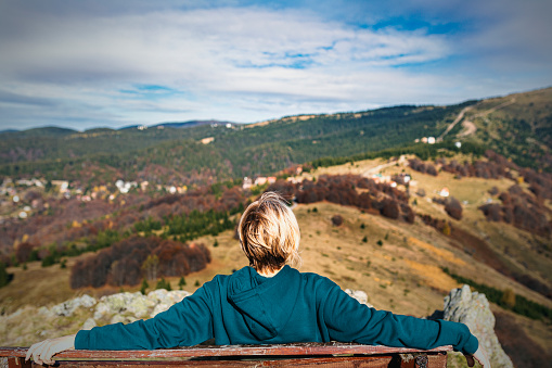 Woman traveler on a walking route, active lifestyle, hiking and travel concept. Resting on the bench