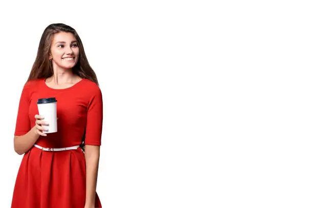 young Girl hold takeaway cup fo coffee. Red dress. White glass with black. Isolated background.