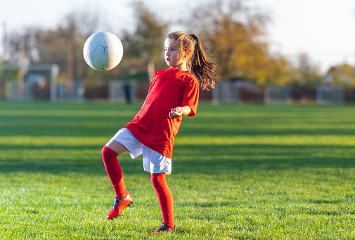 Girl kicks a soccer ball on a soccer field