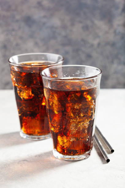 istock glass of cold cola soft drink with ice on concrete background 1284749547