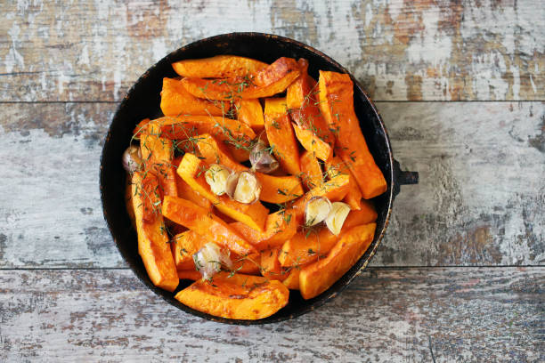 istock Baked pumpkin slices in a pan with herbs and garlic. 1284749586